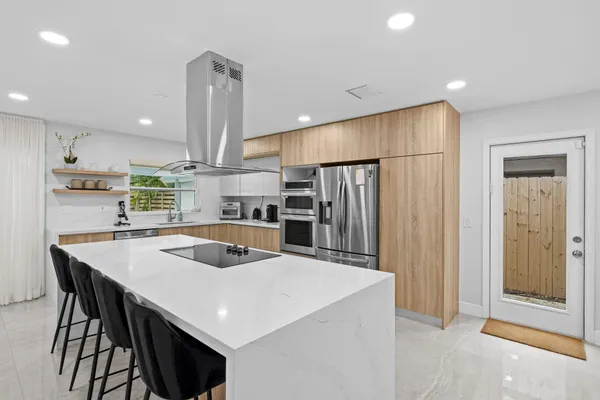 a large kitchen with stainless steel appliances granite countertop a stove and a refrigerator