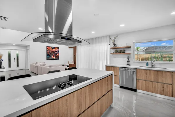 a kitchen with stainless steel appliances a sink and a wooden floor