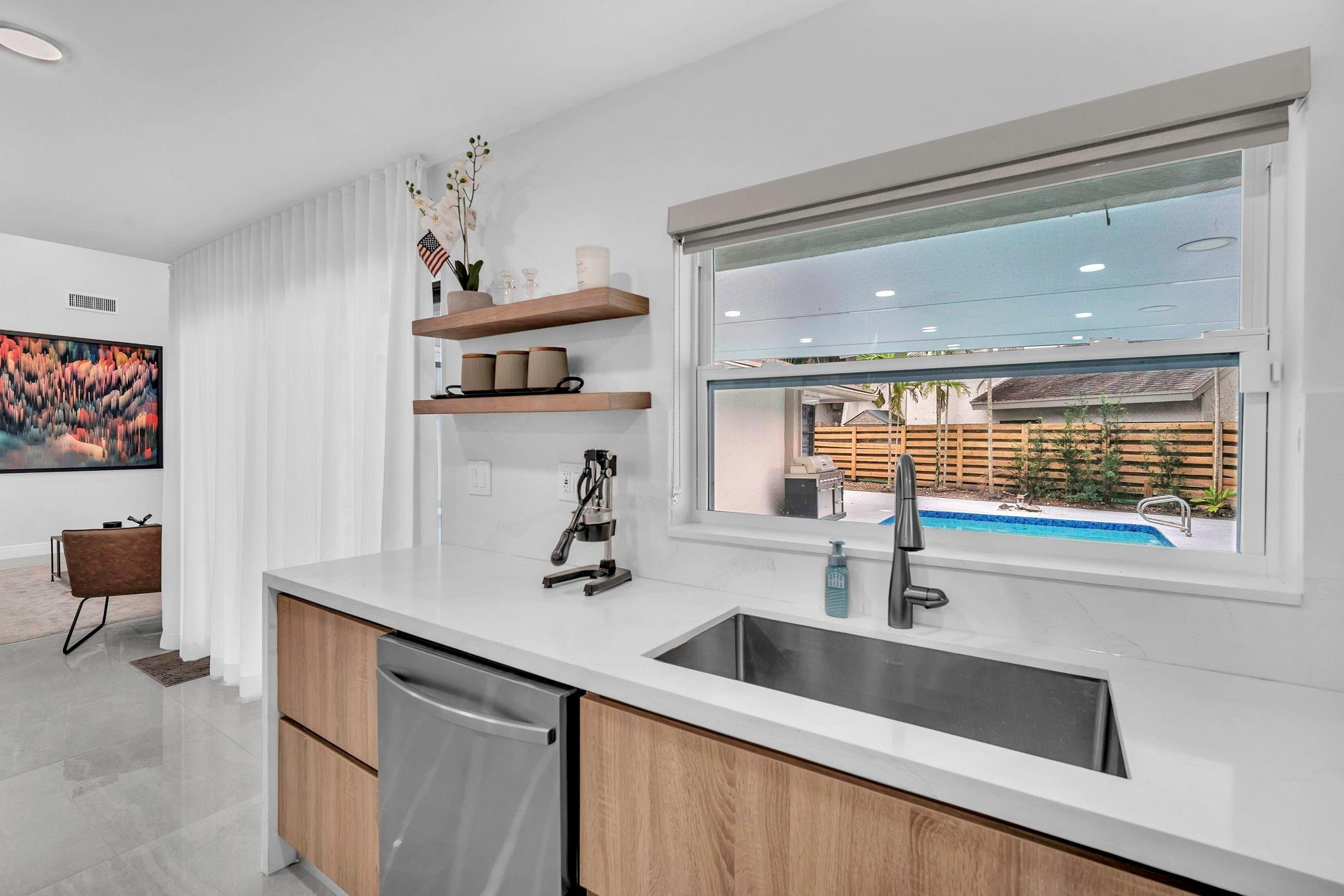 136 Greens Road Hollywood, FL 33021 - Photo 14 of 32 a kitchen with stainless steel appliances a sink and a wooden floor