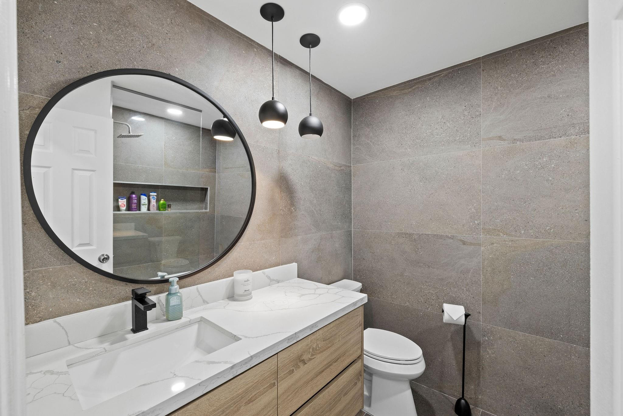 136 Greens Road Hollywood, FL 33021 - Photo 17 of 32 a bathroom with a sink a mirror and a toilet