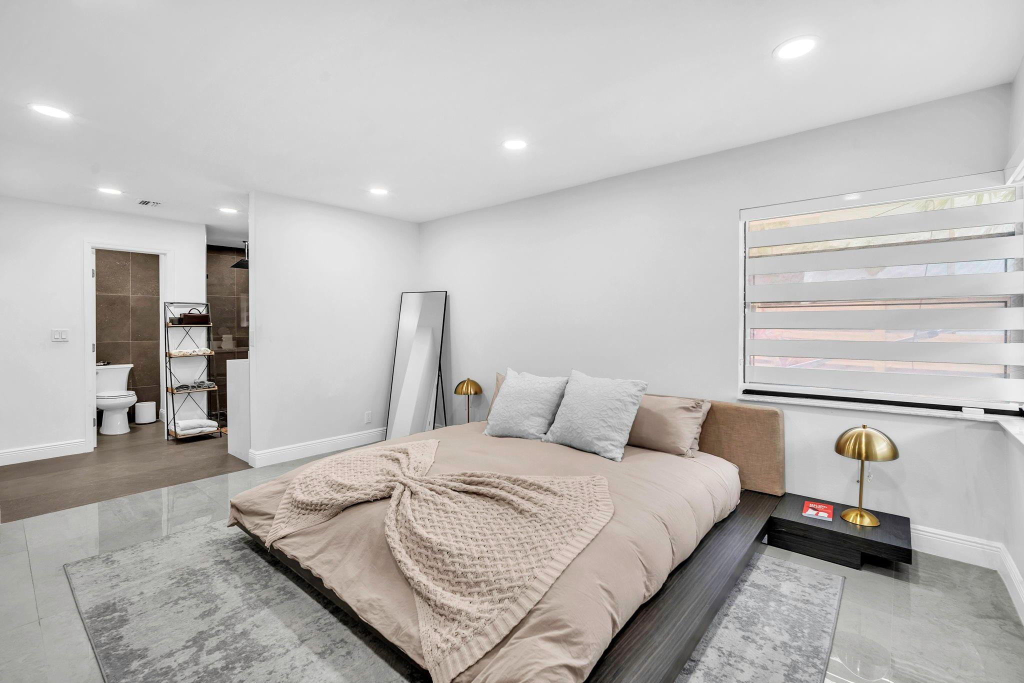 136 Greens Road Hollywood, FL 33021 - Photo 18 of 32 a bedroom with a bed and walk in closet