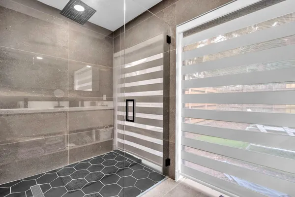 a bathroom with double vanity and a mirror
