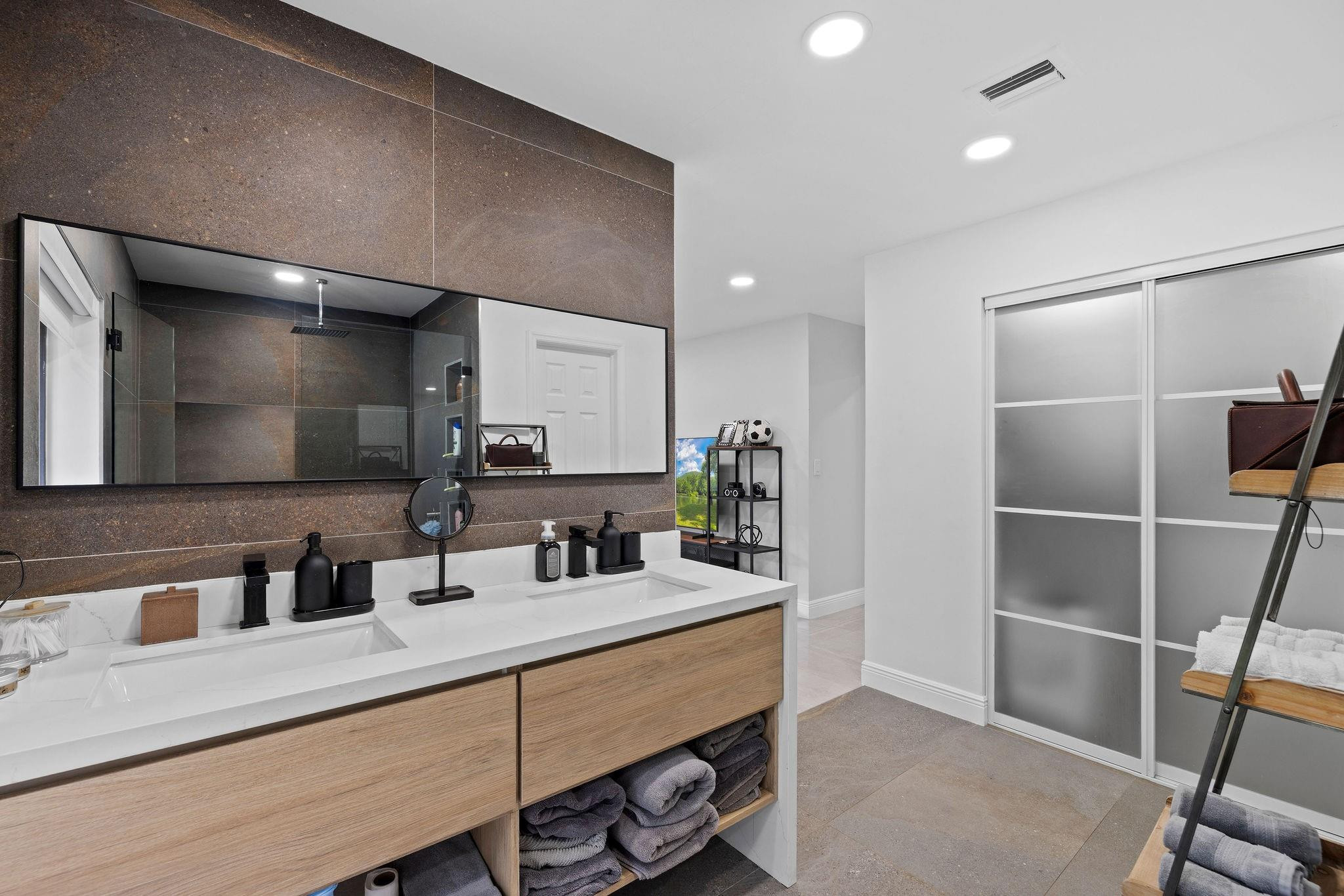 136 Greens Road Hollywood, FL 33021 - Photo 22 of 32 a bathroom with double vanity and a mirror
