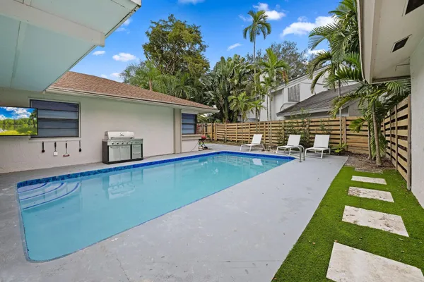 a view of a house with swimming pool and sitting area