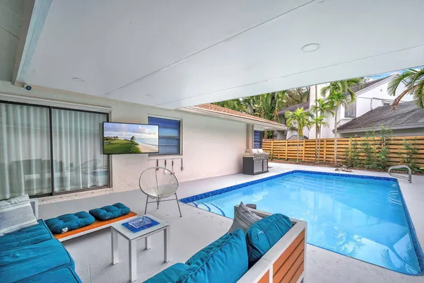 a view of a house with swimming pool and sitting area