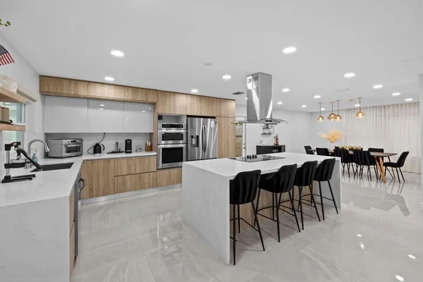 a kitchen with stainless steel appliances kitchen island a stove and a sink
