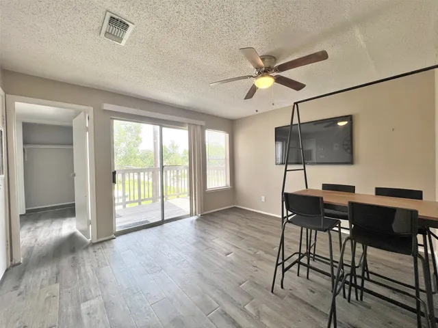 a view of a livingroom with furniture a ceiling fan and wooden floor