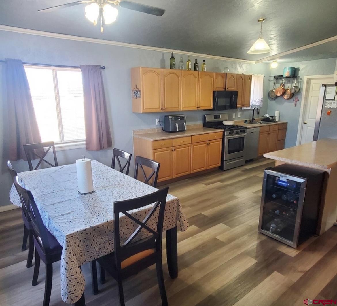 816 Main Street Manassa, CO 81141 - Photo 9 of 23 a kitchen with a table chairs a sink dishwasher stove and cabinets