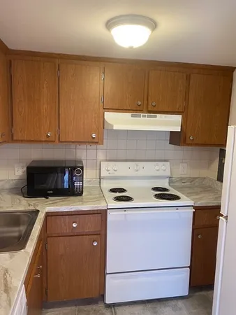 a kitchen with a sink stove and cabinets