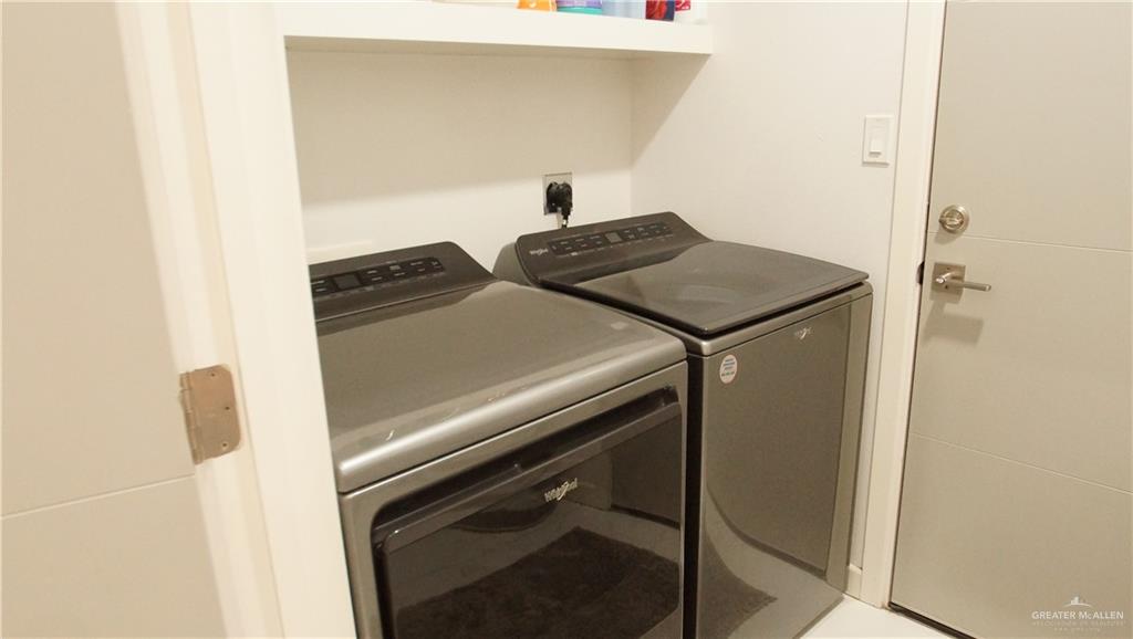 414 Ric Mar Street Edinburg, TX 78541 - Photo 35 of 36 Dedicated laundry area featuring a built-in top shelf, modern washer and dryer units, and a contemporary door with brushed nickel hardware