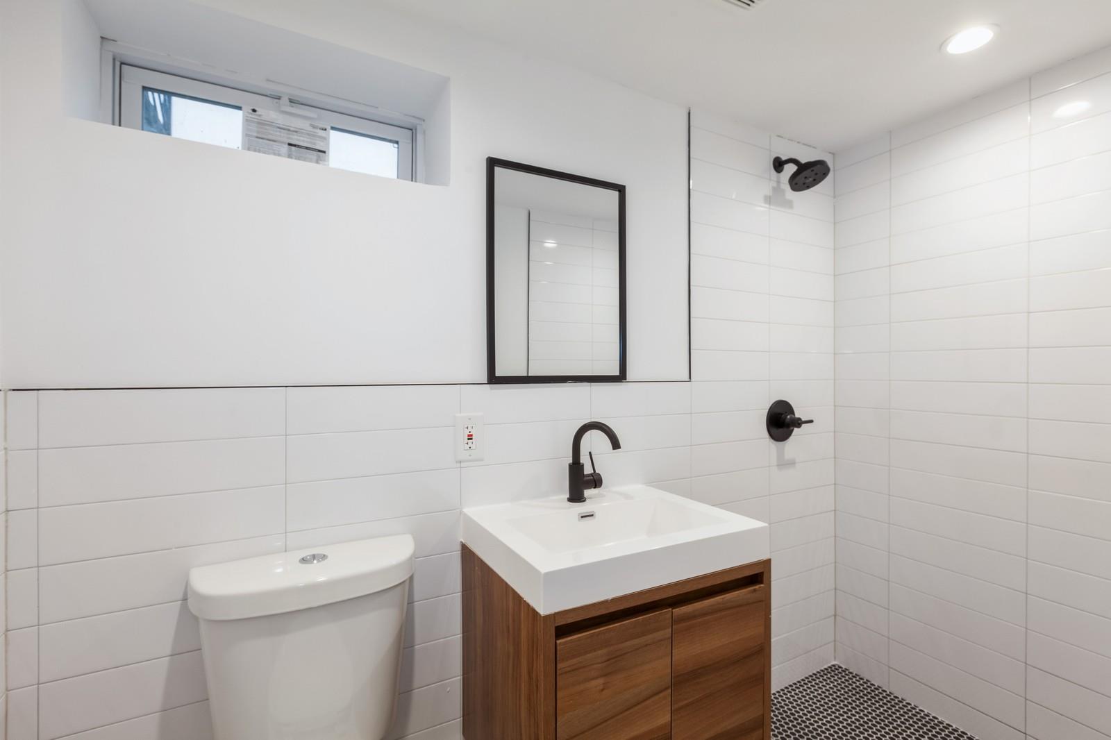 100-03 90th Avenue Queens, NY 11418 - Photo 12 of 18 Bathroom featuring tile walls, a tile shower, toilet, and vanity