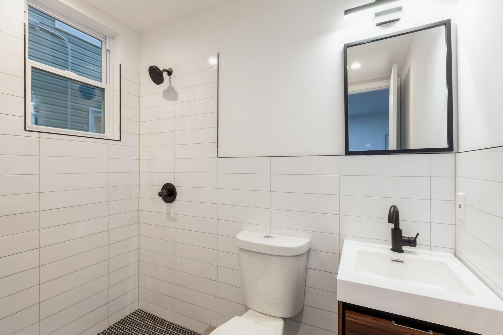 100-03 90th Avenue Queens, NY 11418 - Photo 4 of 18 Full bathroom featuring tile walls, vanity, toilet, and tiled shower