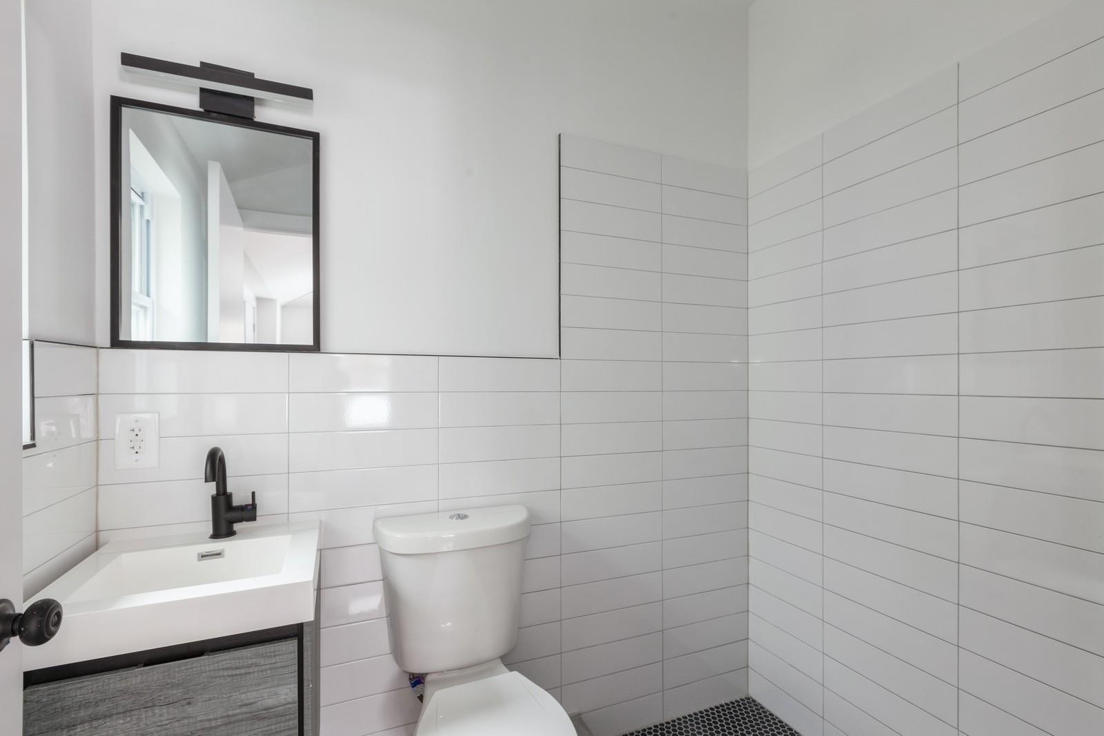 100-03 90th Avenue Queens, NY 11418 - Photo 6 of 18 Bathroom featuring tile walls, toilet, and vanity