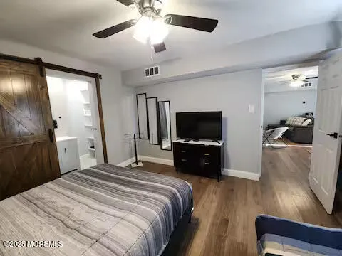 a bedroom with a bed and a flat tv screen on dresser