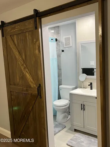 a bathroom with a sink a toilet and shower
