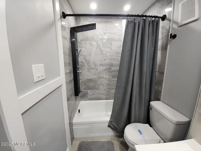 a bathroom with a shower a toilet and a shower