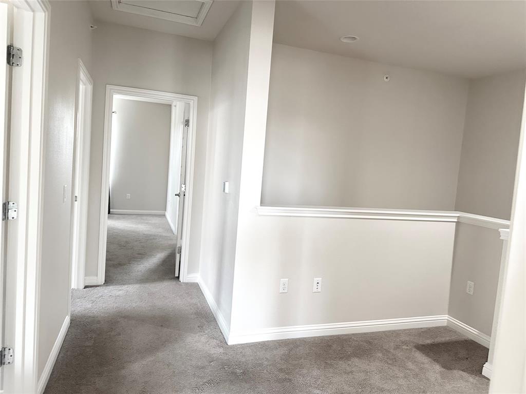 6814 East Riverside Drive, Unit 26 Austin, TX 78741 - Photo 8 of 21 A well-lit interior hallway features soft carpet flooring, connecting various rooms.