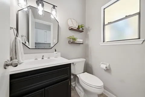 a bathroom with a toilet a sink and mirror