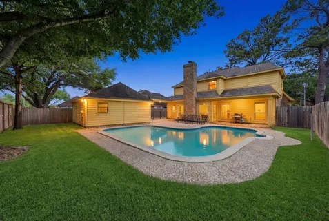a view of a house with a swimming pool and a yard