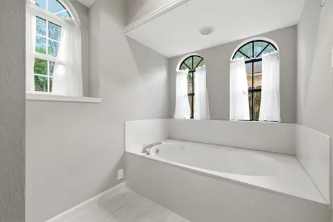 a bathroom with a bathtub and a window