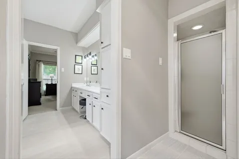 a bathroom with a double vanity sink mirror and shower