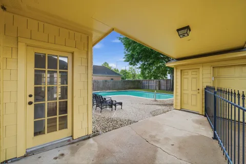 a view of a backyard with table and chairs and wooden fence