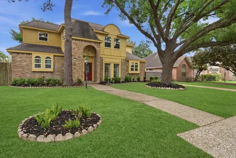 a front view of a house with a garden