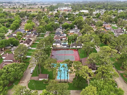 an aerial view of residential house with outdoor space and trees all around