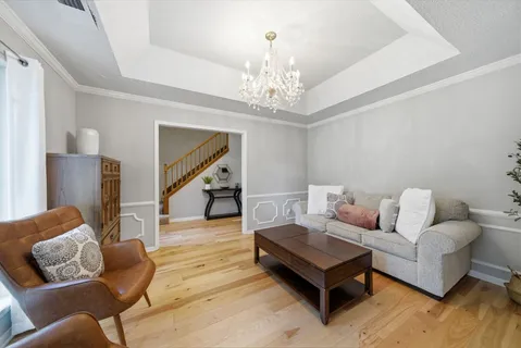 a living room with furniture and a chandelier
