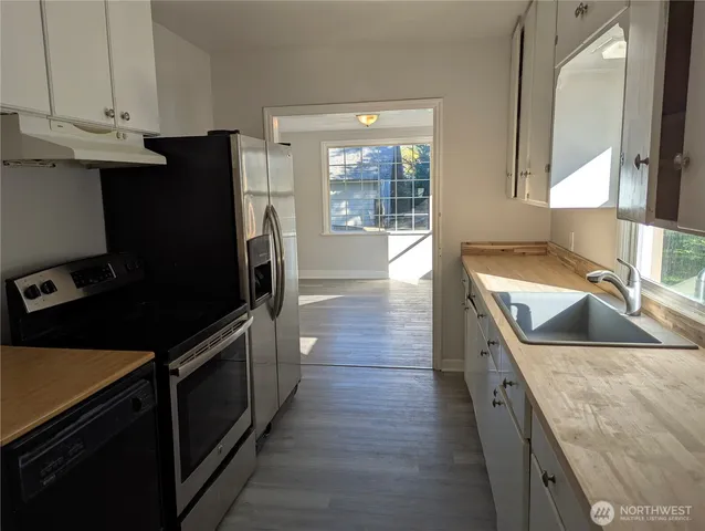 a kitchen with stainless steel appliances granite countertop a sink a stove and a refrigerator