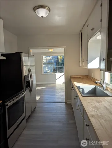 a kitchen with stainless steel appliances granite countertop a sink a stove and a refrigerator