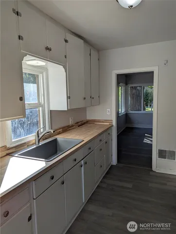 a kitchen with granite countertop white cabinets and sink