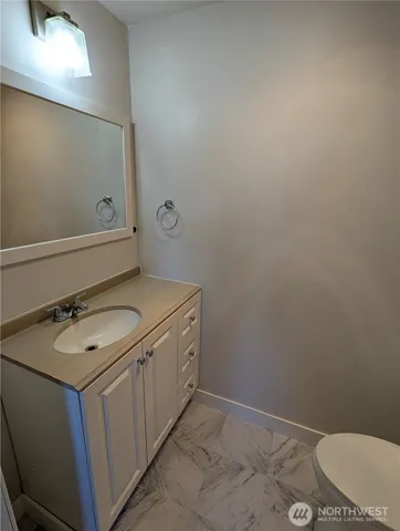 a bathroom with a granite countertop toilet and sink