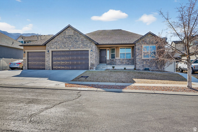 141 Wolverine Creek Elk Ridge, UT 84651 - Photo 42 of 47 Craftsman house featuring driveway, a garage, stone siding, and roof with shingles