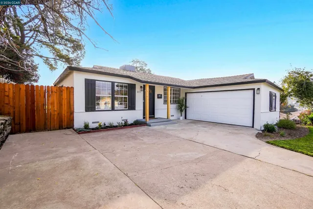 a kitchen with stainless steel appliances granite countertop a refrigerator a stove a sink a dining table and chairs with wooden floor