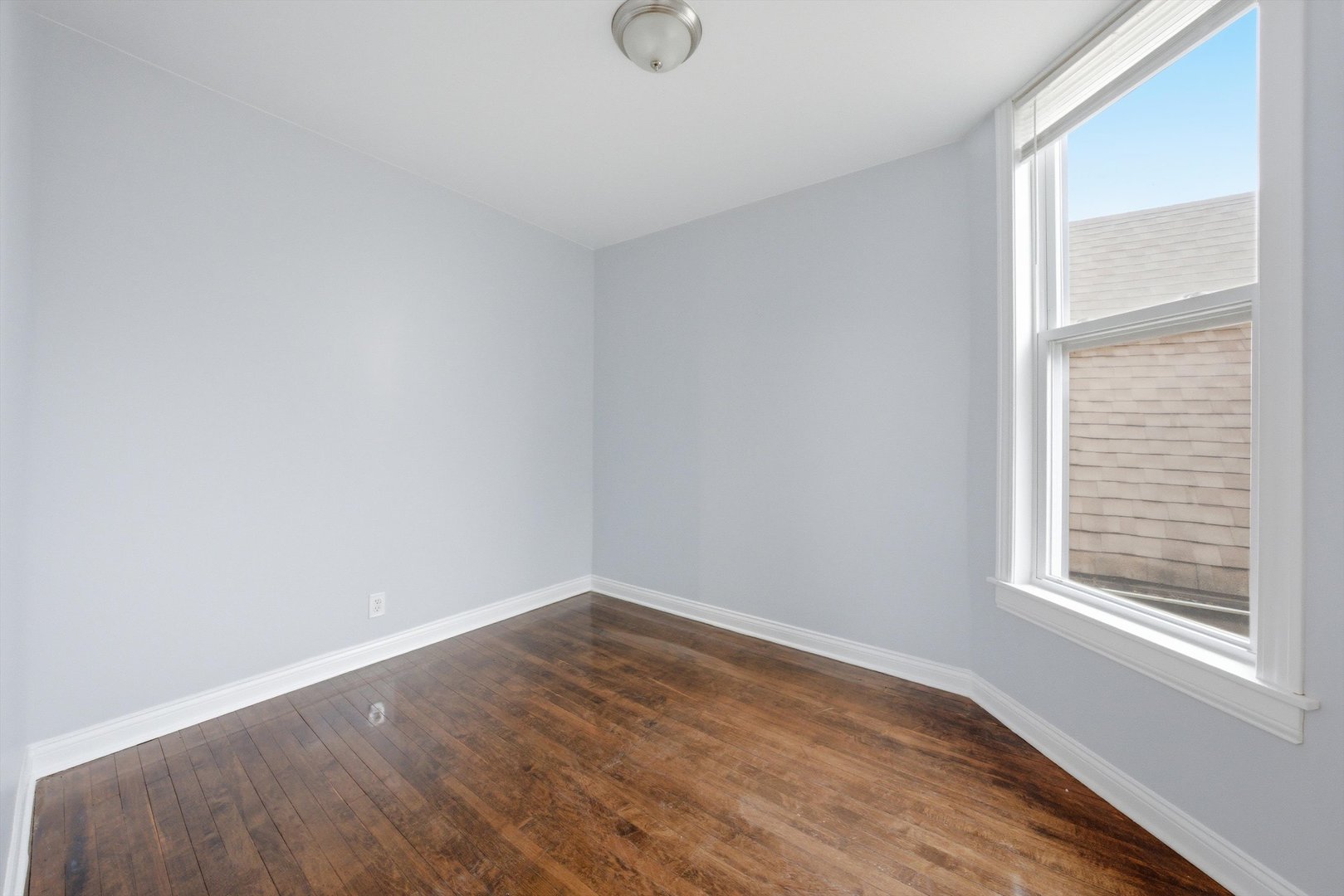 7242 South May Street, Unit 2 Chicago, IL 60621 - Photo 9 of 12 wooden floor in an empty room with a window