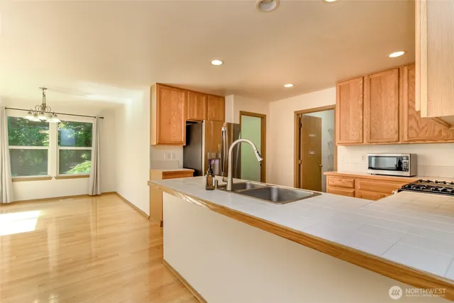a large kitchen with stainless steel appliances granite countertop a sink and a large window