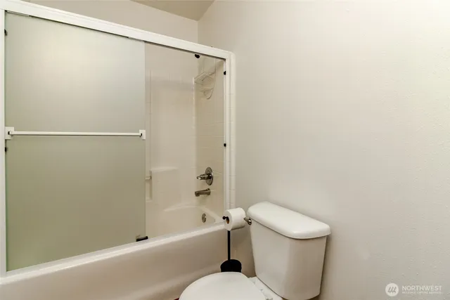 a white toilet sitting next to a bath tub