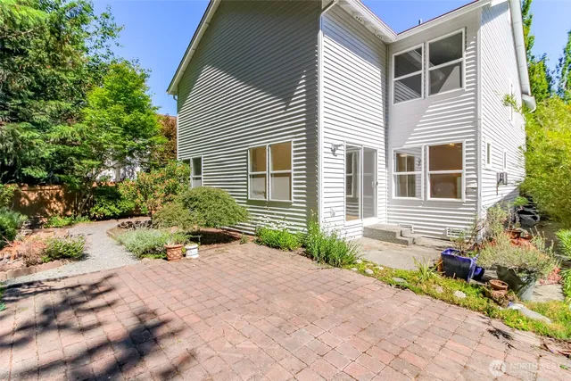 a front view of a house with a yard and potted plants