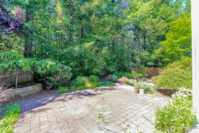 a view of backyard with table and chairs and potted plants