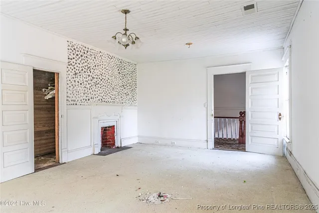 an empty room with a fireplace and cabinet