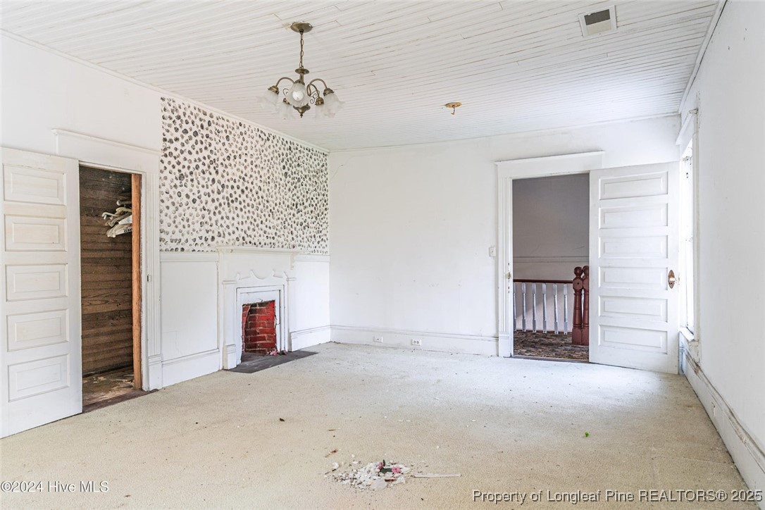 801 Monroe Street Carthage, NC 28327 - Photo 17 of 20 an empty room with a fireplace and cabinet
