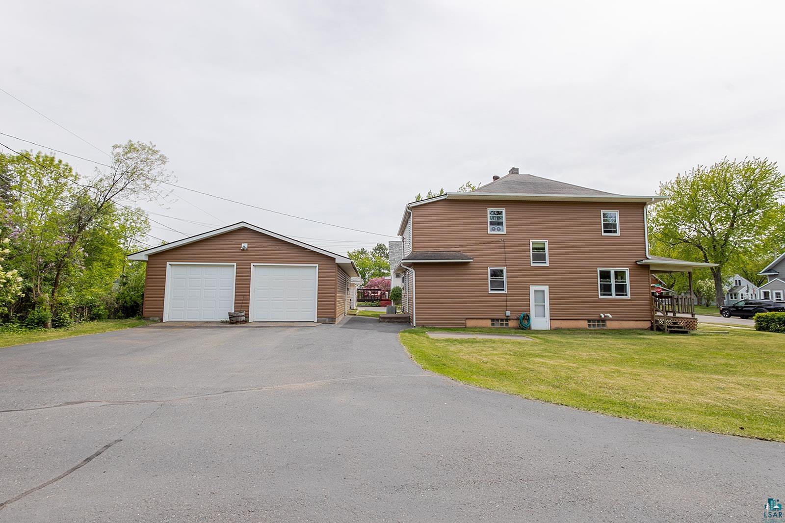 438 9th Street Cloquet, MN 55720 - Photo 5 of 27 Two-car detached garage with white overhead doors and ample paved driveway space