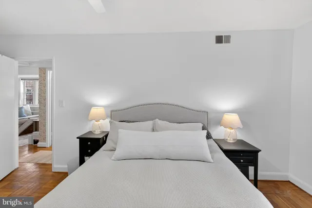 a bedroom with a bed and wooden floor