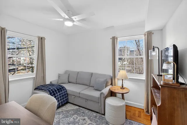 a living room with furniture a flat screen tv and a window