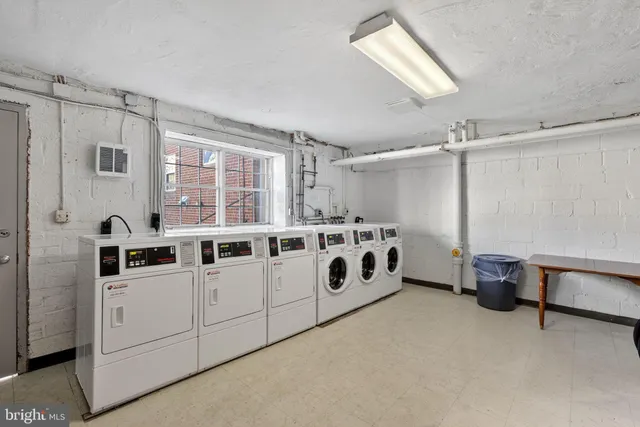 a utility room with stainless steel appliances kitchen island granite countertop a refrigerator and a stove