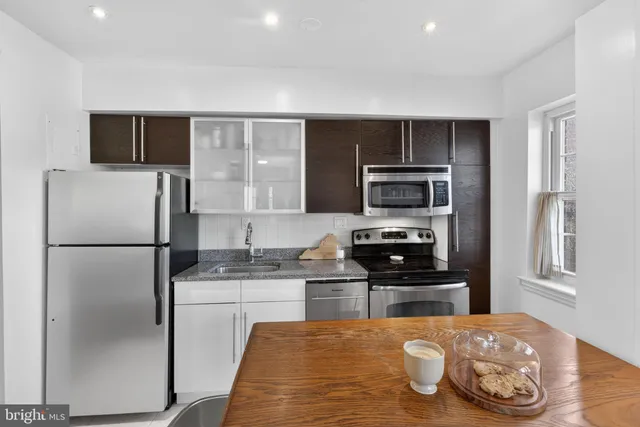 a kitchen with granite countertop a refrigerator stove and oven