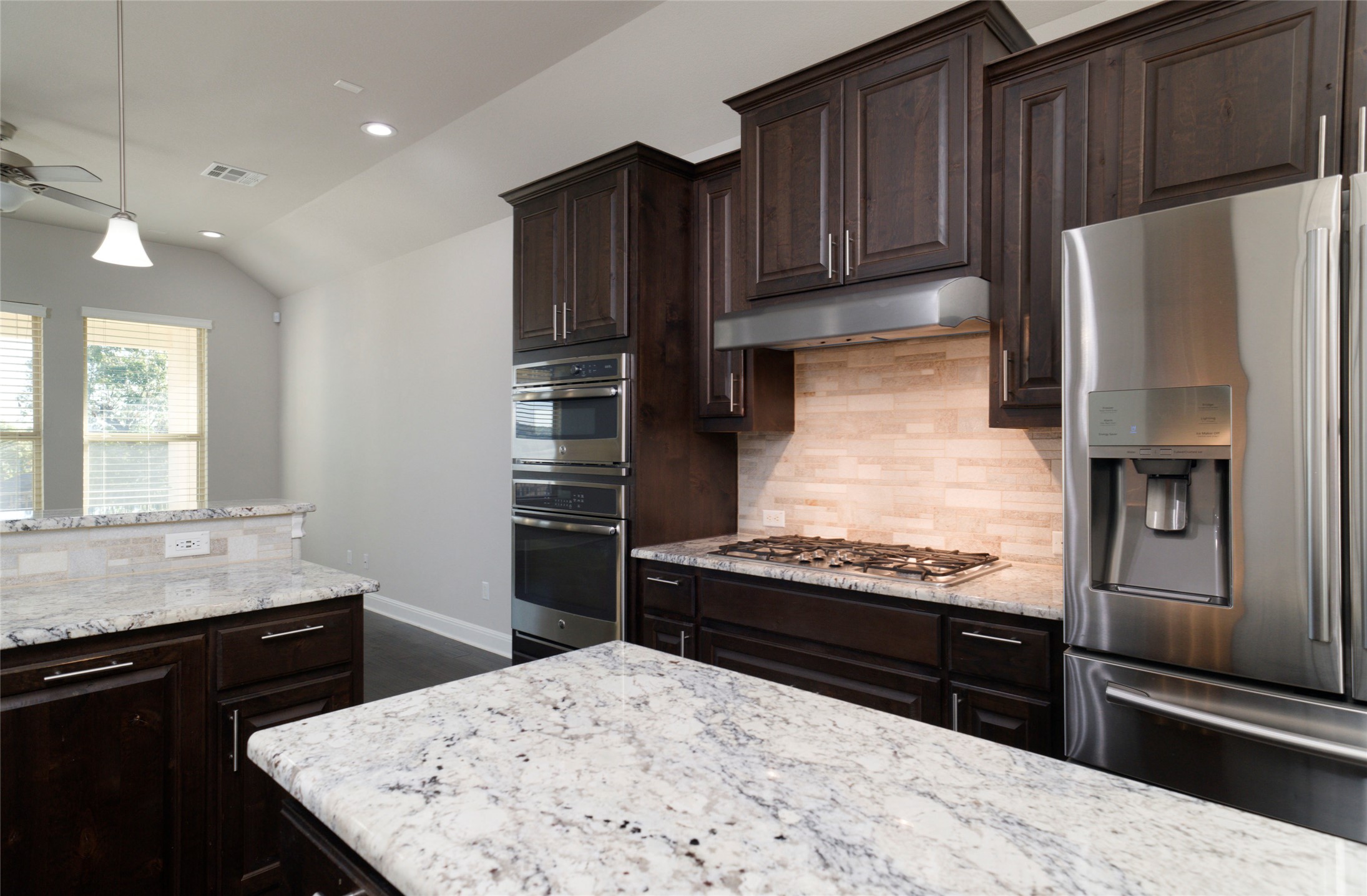 4001 Goodnight Trail Leander, TX 78641 - Photo 15 of 35 a kitchen with stainless steel appliances kitchen island granite countertop a refrigerator and a stove top oven