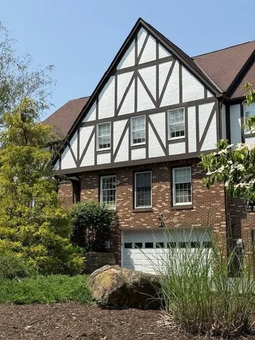 a front view of a house with a yard and potted plants