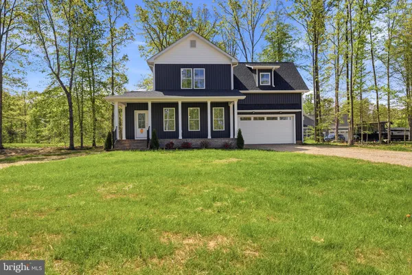 a view of a house with a big yard and large trees